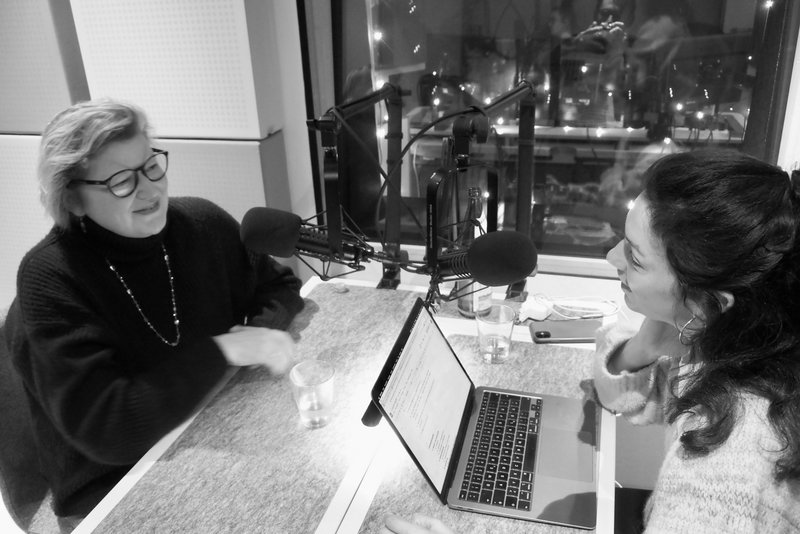 Ein schwarz-weiß-Bild in dem Claudia Watzel mit Nadia Kailouli in dem Podcast "einbiszwei" spricht.